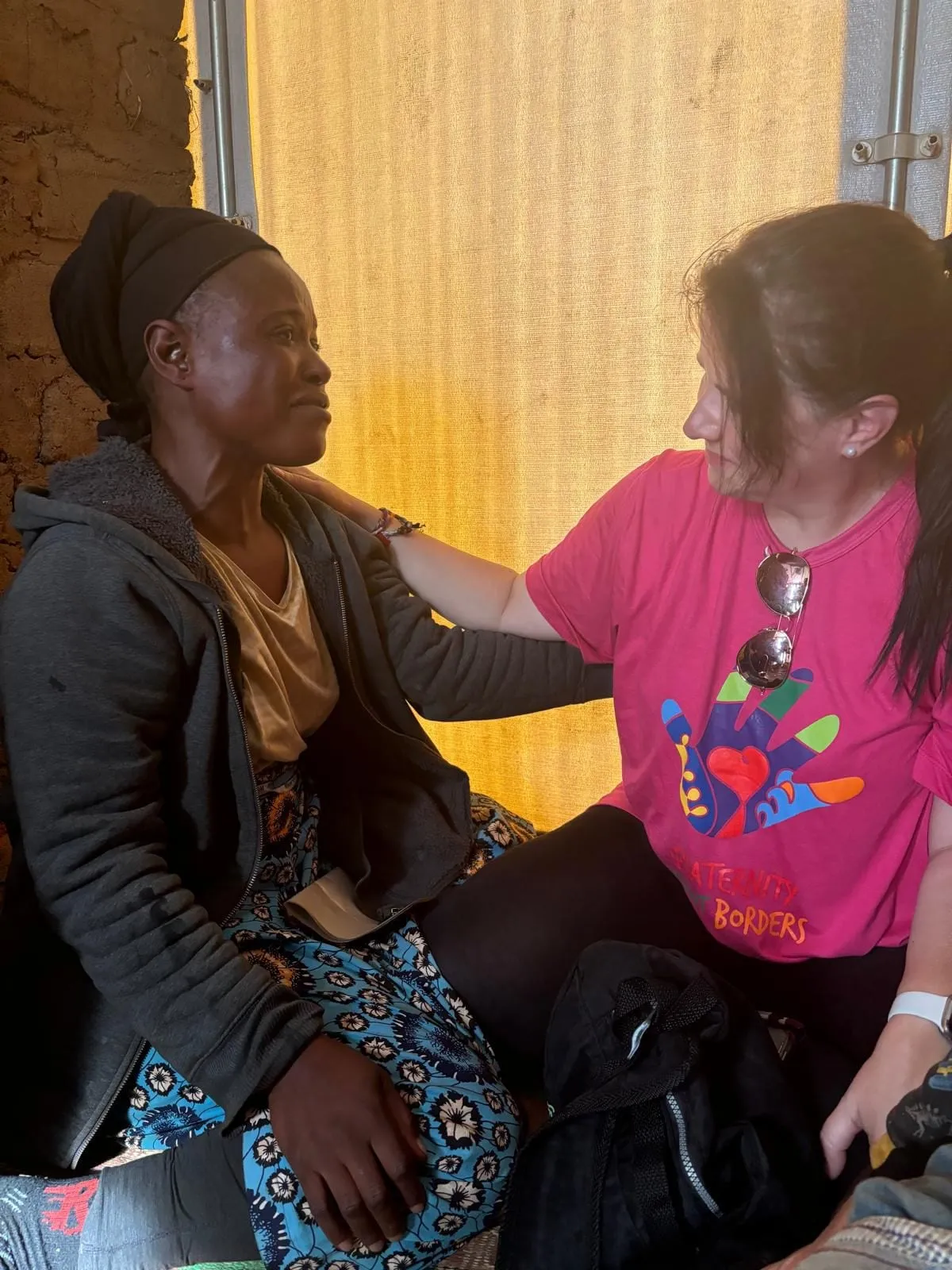 Luísa Marteleto sharing a warm embrace with a woman from the community