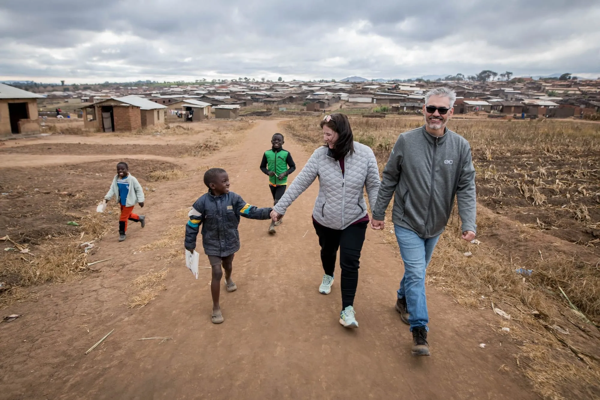 Luísa Marteleto walking with children in a community in Malawi
