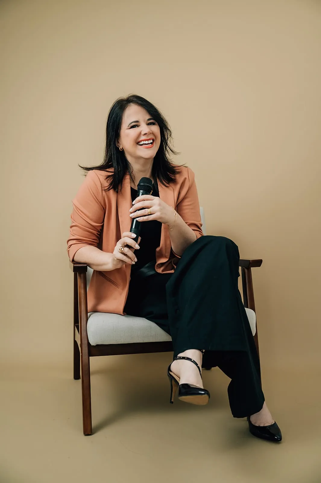 Luísa Marteleto seated with a microphone in the studio