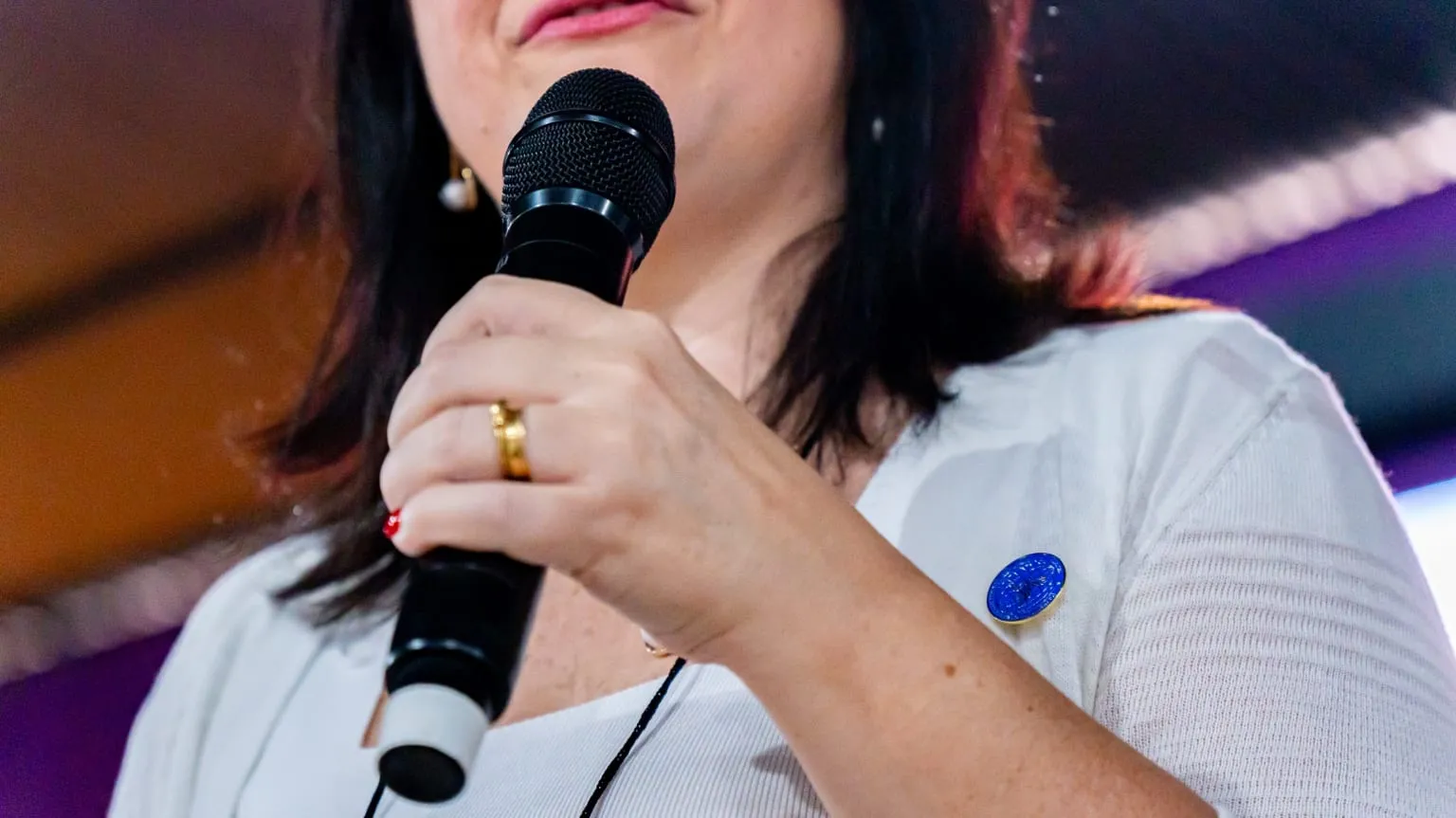 Close-up of Luísa Marteleto holding the microphone