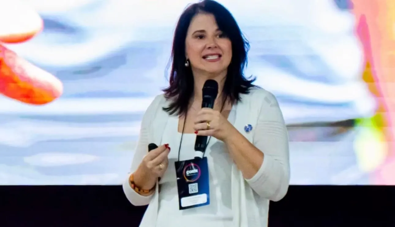Luísa Marteleto giving a talk with a microphone