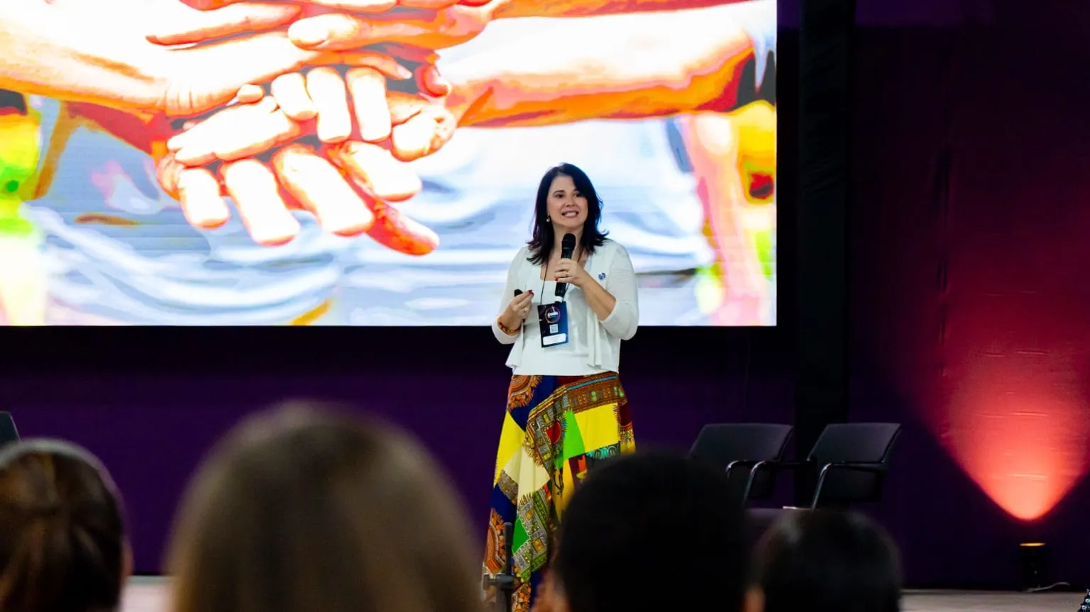 Luísa Marteleto on stage, speaking to the audience