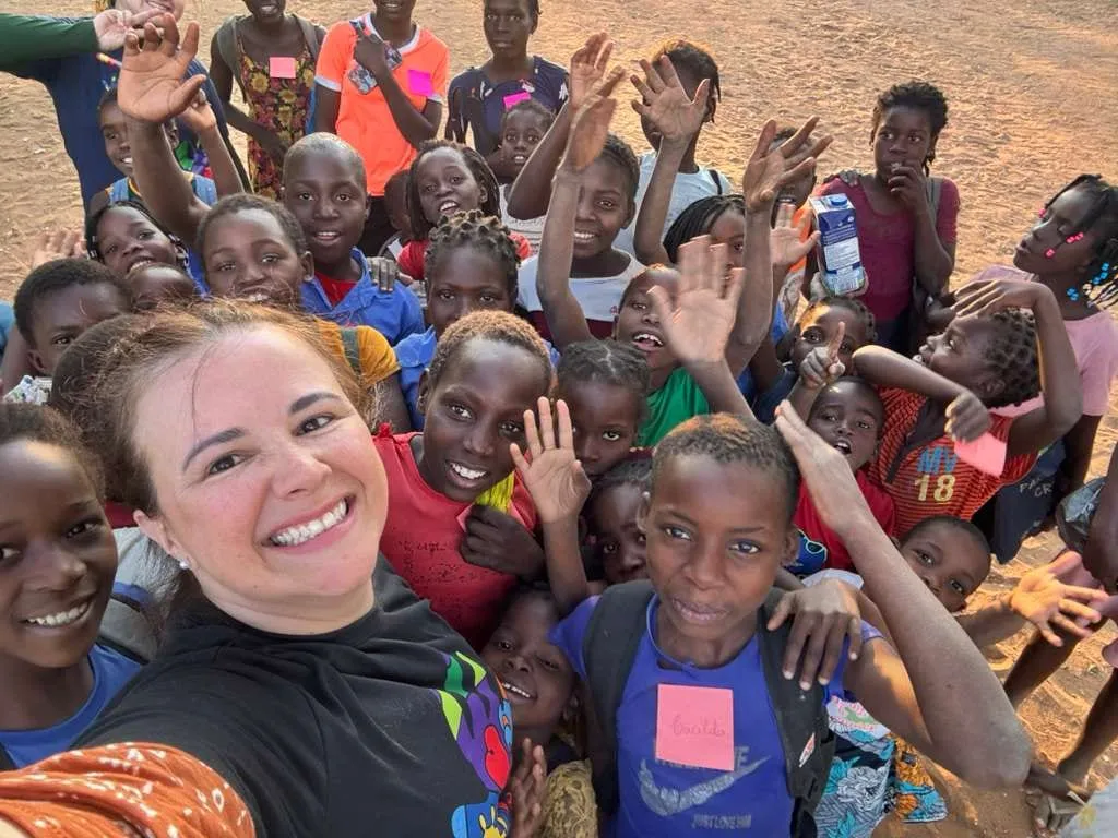 Luísa Marteleto with a group of smiling children